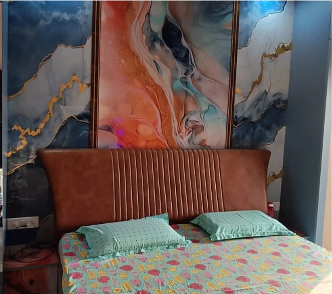 Bedroom with marble-pattern feature wall and upholstered headboard — ORGANIC INDIA Jaipur